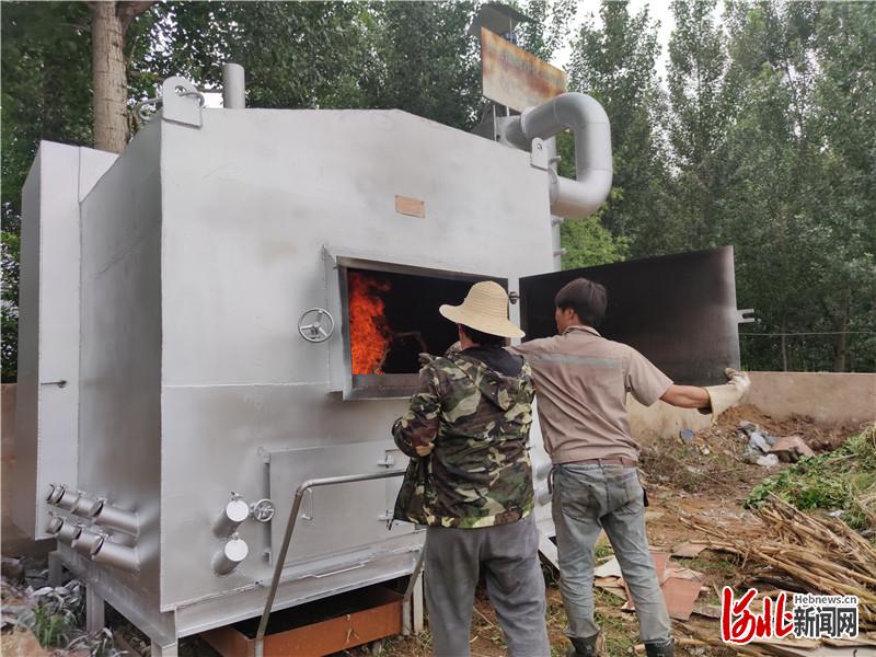 村民正在使用农用焚烧净化处理器焚烧农作物垃圾。